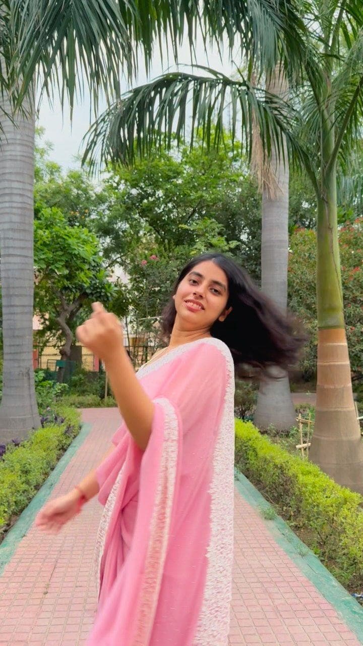 Aishwanee House pink saree worn outdoors among palms